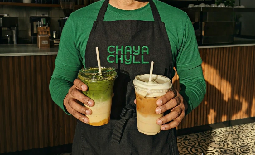 Chaya Chyll branding, drinks held by a person in a branded apron